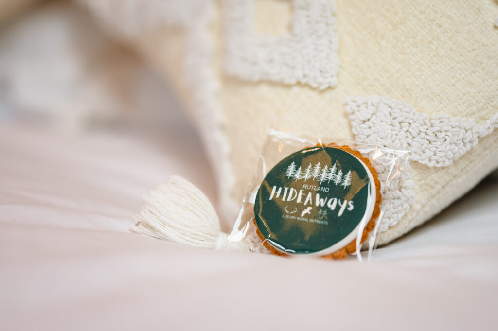 Hospitality detail shot of a personalised biscuit on a pillow at Rutland Hideaways luxury lodges