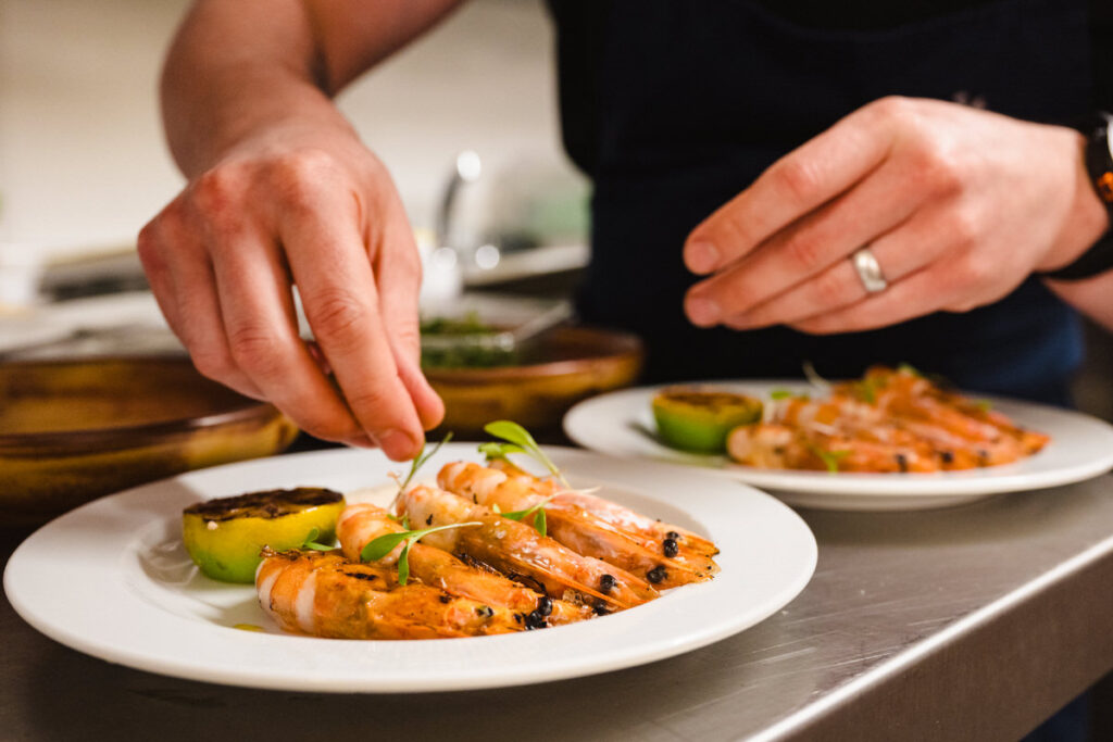 Finishing touches added to gourmet fish entree for hotel menu